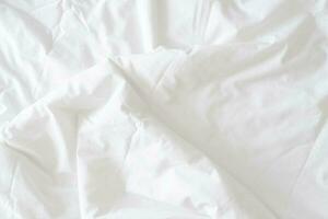 resumen modelo de blanco estropeado cama hoja. blanco arrugado tela textura ondulado superficie. cerca arriba. foto