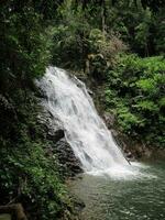 Waterfall cascade on mountain rocks photo