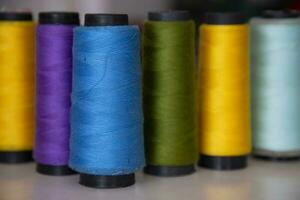 Some multicolor Spools of  swings thread Close-up Focus photo