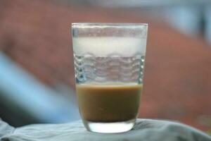 a cup of milk coffee with a blurred background photo