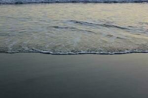 seawater foam on the beach sand photo