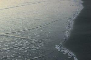 seawater foam on the beach sand photo