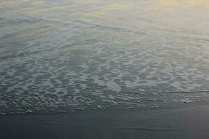 seawater foam on the beach sand photo