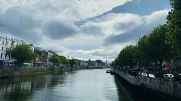 Nice view in Dublin. Nature, buildings by the river. Blue clouds. photo