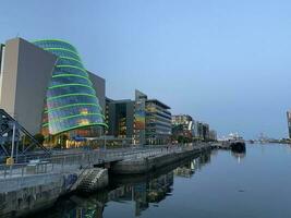 Multi-storey beautiful buildings in Dublin by the river. New building. Ship on a blue background. photo