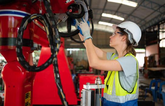 un ingenieros instalando y pruebas un grande robótico brazo. antes de enviando eso a clientes para utilizar en el industria foto