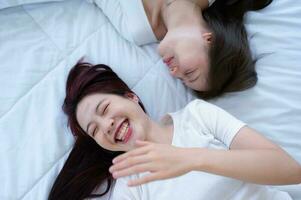 On a rainbow flag, an LGBT couple laughs cheerfully. photo