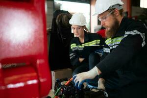 ambos de ingenieros instalando un pequeño robótico brazo es siendo instalado para pruebas. antes de enviando a clientes para industrial usar. foto