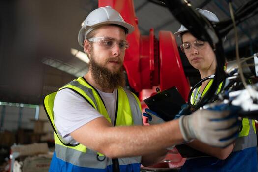 ambos de ingenieros instalando y pruebas un grande robótico brazo. antes de enviando eso a clientes para utilizar en el industria foto