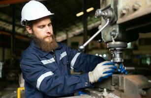 Portrait of mechanical engineers are checking the working condition of an old machine that has been used for some time. In a factory where natural light shines onto the workplace photo