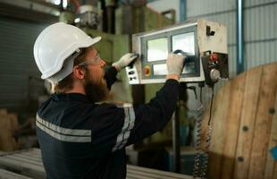 Portrait of mechanical engineers are checking the working condition of an old machine that has been used for some time. In a factory where natural light shines onto the workplace photo
