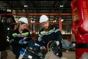 ambos de ingenieros instalando un pequeño robótico brazo es siendo instalado para pruebas. antes de enviando a clientes para industrial usar. foto