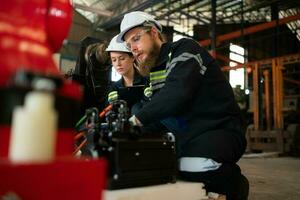 Both of engineers installing a small robotic arm is being installed for testing. before sending to customers for industrial use. photo