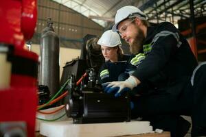 ambos de ingenieros instalando un pequeño robótico brazo es siendo instalado para pruebas. antes de enviando a clientes para industrial usar. foto