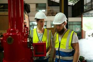 Both of mechanical engineers are checking the working condition of the new machine after completing the installation photo