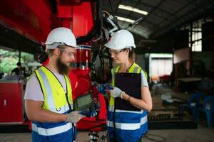 Both of engineers installing and testing a large robotic arm. before sending it to customers for use in the industry photo