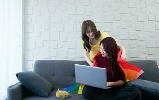 LGBT couples use rainbow flags to cover their loved ones. Working on the sofa in the living room of the house photo