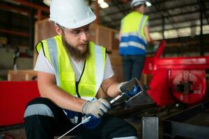 A mechanical engineer measuring product dimensions of new machinery installed photo