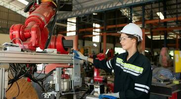 hembra eléctrico ingeniero con el misión de instalando un robot brazo eléctrico sistema foto