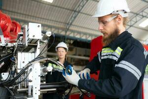 eléctrico ingeniero con el misión de instalando un robot brazo eléctrico sistema foto