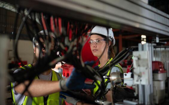 ambos de ingenieros instalando y pruebas un grande robótico brazo. antes de enviando eso a clientes para utilizar en el industria foto