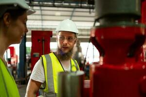 Both of mechanical engineers are checking the working condition of the new machine after completing the installation photo