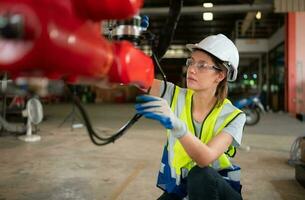 An engineers installing and testing a large robotic arm. before sending it to customers for use in the industry photo