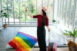 A homestay in the countryside, a natural attraction Welcome LGBT couples by cover a rainbow flag on the mattress in a bedroom overlooking natural beauty. have to take a selfie to show friends. photo