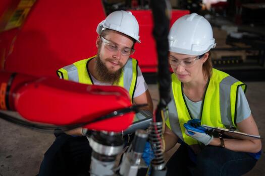 ambos de ingenieros instalando y pruebas un grande robótico brazo. antes de enviando eso a clientes para utilizar en el industria foto