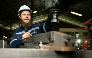 Portrait of mechanical engineers are checking the working condition of an old machine that has been used for some time. In a factory where natural light shines onto the workplace photo