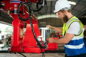 An engineers installing and testing a large robotic arm. before sending it to customers for use in the industry photo