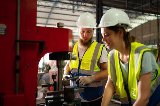 Both of mechanical engineers are checking the working condition of the new machine after completing the installation photo
