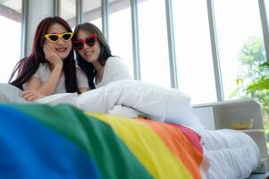 The LGBT couple trying on fashion glasses together as they arrive in hotel room to prepare for nature tourism in the countryside photo