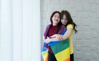 LGBT couples cover rainbow flags around their loved ones to keep warm and gaze out their hotel room windows together. photo