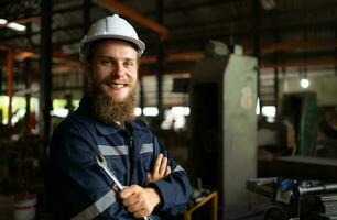 Portrait of mechanical engineers are checking the working condition of an old machine that has been used for some time. In a factory where natural light shines onto the workplace photo