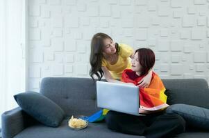 LGBT couples use rainbow flags to cover their loved ones. Working on the sofa in the living room of the house photo