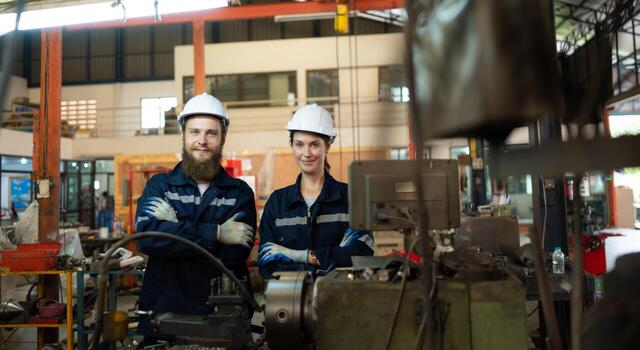 Portrait of mechanical engineers are checking the working condition of an old machine that has been used for some time. In a factory where natural light shines onto the workplace photo