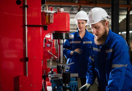 Both of mechanical engineers are checking the working condition of the new machine after completing the installation photo