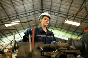 Portrait of mechanical engineers are checking the working condition of an old machine that has been used for some time. In a factory where natural light shines onto the workplace photo