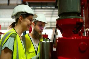 Both of mechanical engineers are checking the working condition of the new machine after completing the installation photo