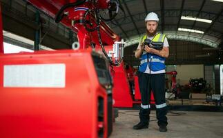 An engineers installing and testing a large robotic arm. before sending it to customers for use in the industry photo