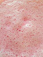 Texture of Fresh Milkshake or smoothie in glass with strawberries top view, close up. Concept of summer drink photo