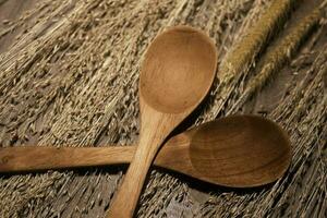 wooden spoon and dry reeds on wooden table photo