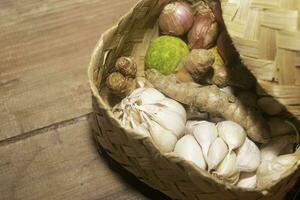 The vegetables ingredients for cooking on the woven bamboo. herbs photography. suitable for kitchen background image photo