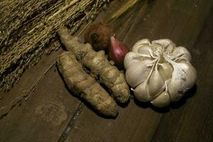 Fresh garlic , lime, red union and turmeric  on a wooden table photo