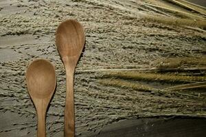 wooden spoon and dry reeds on a wooden table photo