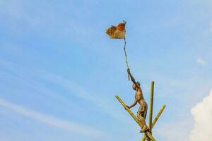 17 august 2021- A man waving the red and white flag against a blue sky as a background at the end of a race to commemorate the independence day of the Republic of Indonesia photo