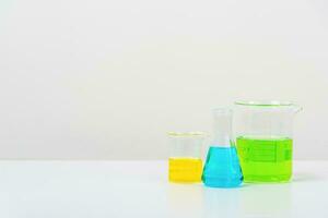 some test tube on the white table  with beakers, flasks, and test tubes filled with colorful liquids photo