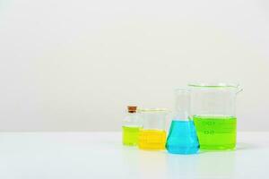 some test tube on the white table  with beakers, flasks, and test tubes filled with colorful liquids photo