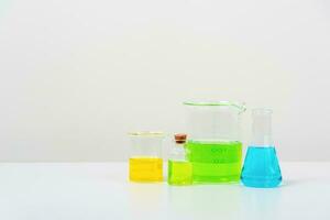 some test tube on the white table  with beakers, flasks, and test tubes filled with colorful liquids photo